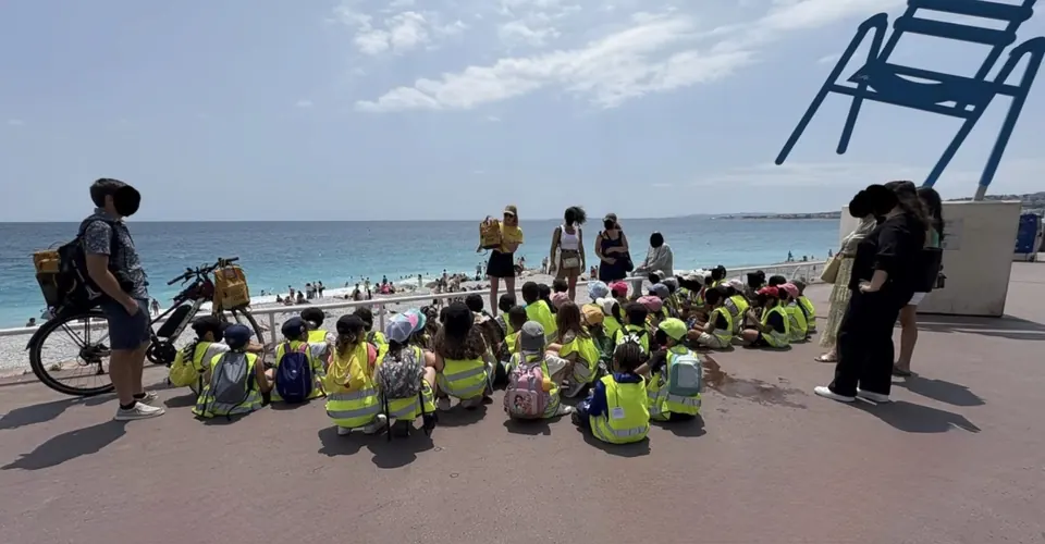 Classe en sortie scolaire assise face &agrave; la mer sur la Promenade des Anglais &agrave; Nice